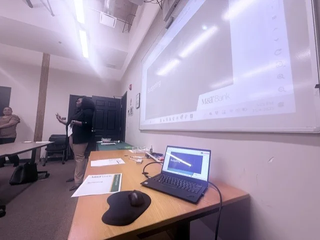 A MoneyWise financial session under way in a classroom, M&T Bank on the projector screen.